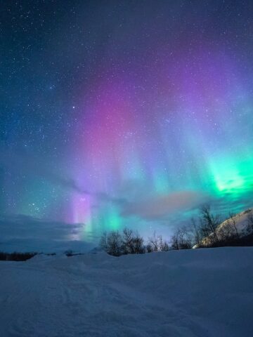 northern lights over snow-capped mountians, Tromso Norway, aurora borealis in norway