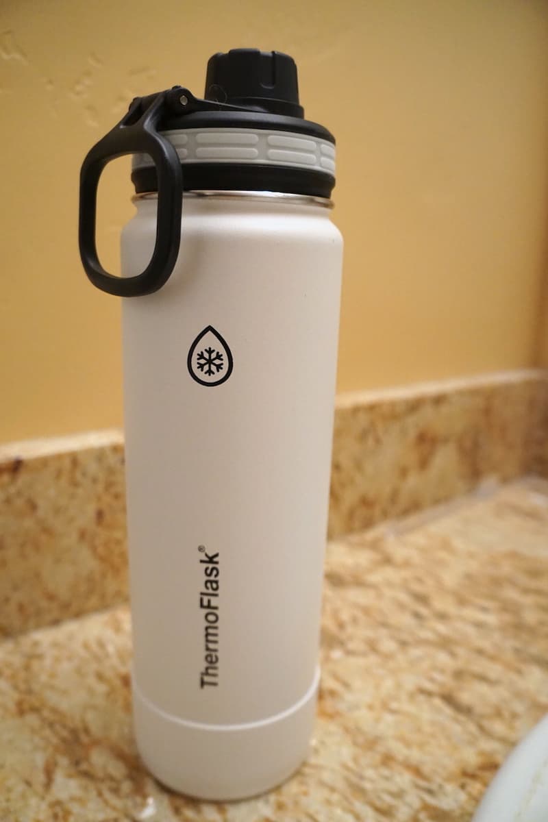 white Thermoflask stainless steel 24 ounce dual insulated water bottle with black lid and wide handle