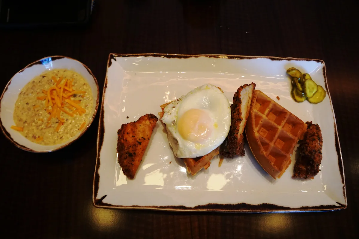 chicken and waffles topped with a fried egg and sausage gravy and pickles at Pechanga Lobby Bar and Grill