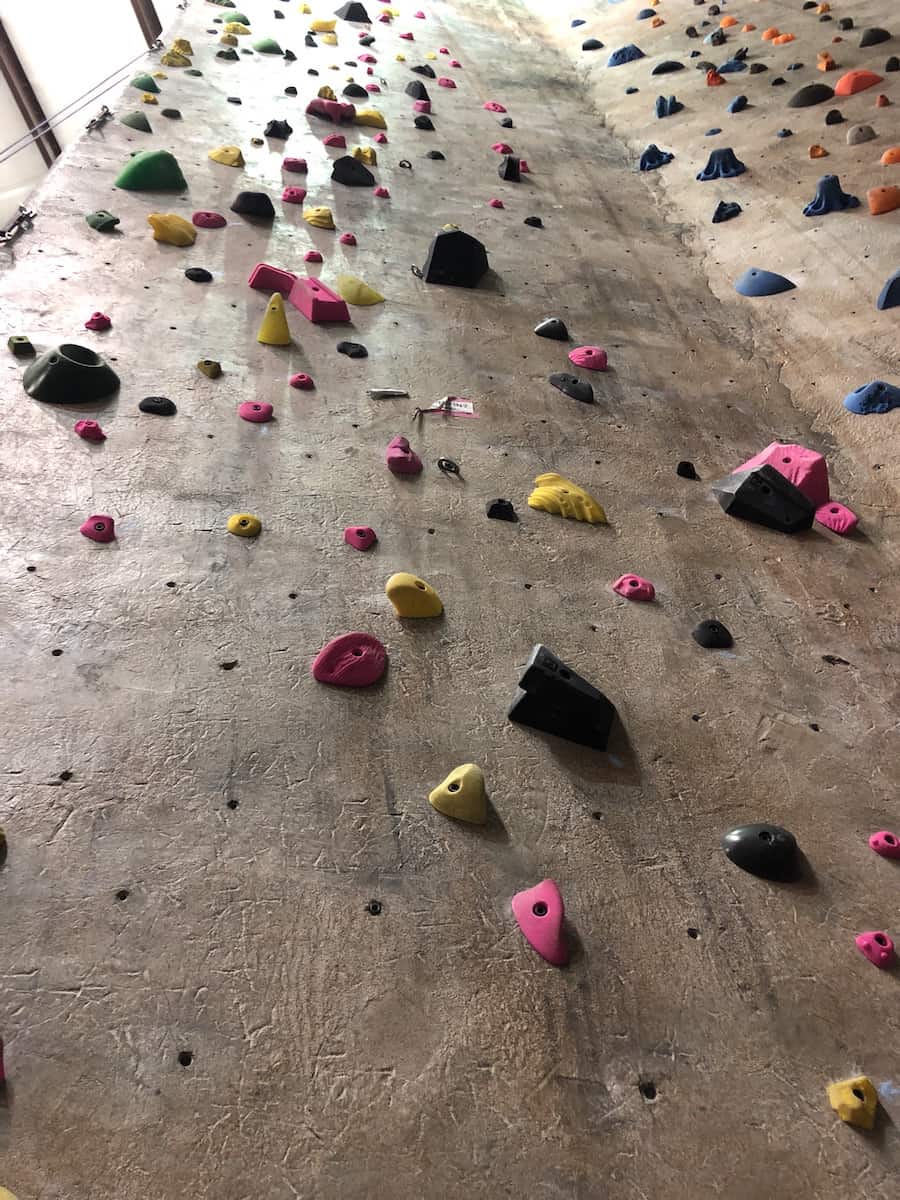 view of indoor rock climbing wall looking up from the bottom