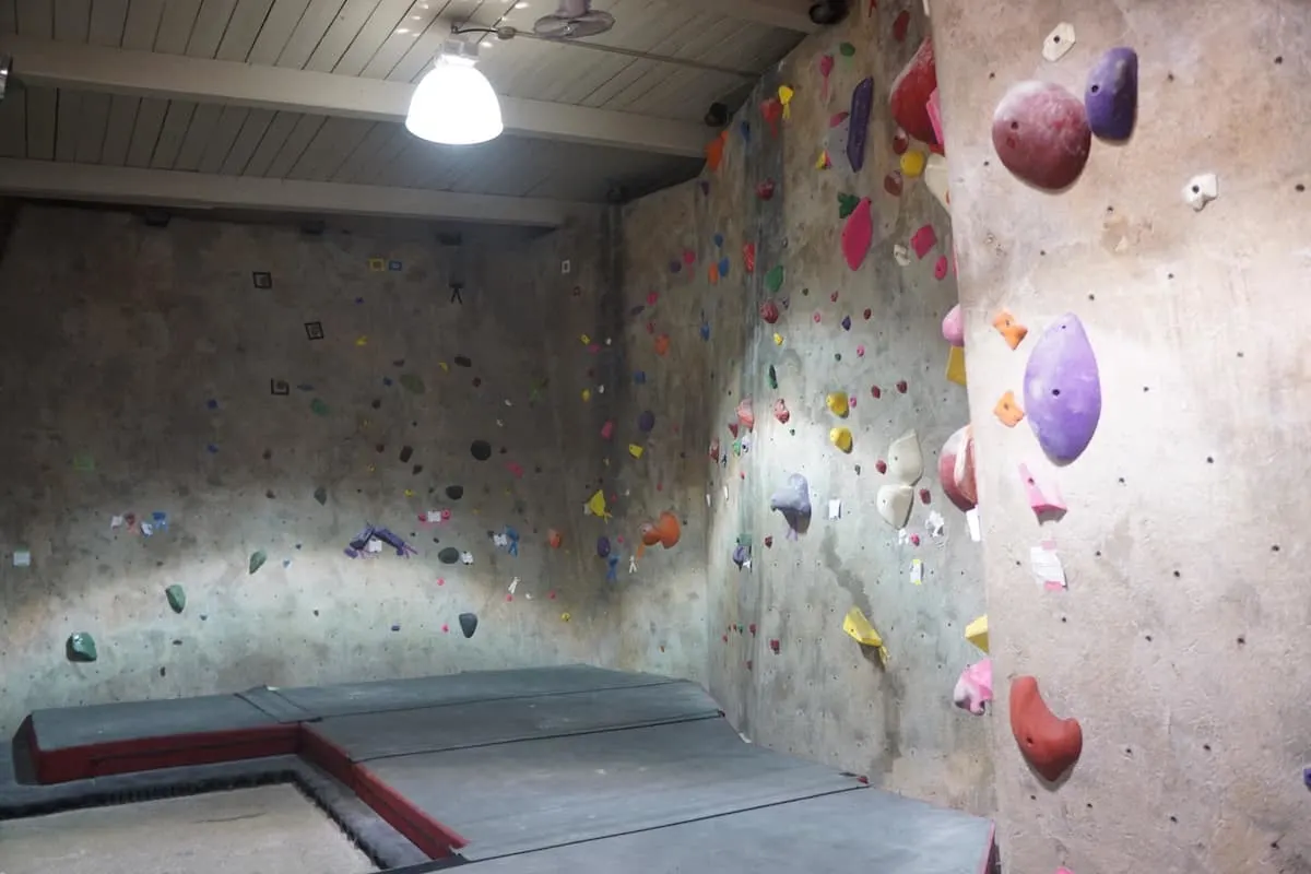 low indoor rock climbing wall with thick pads on floor