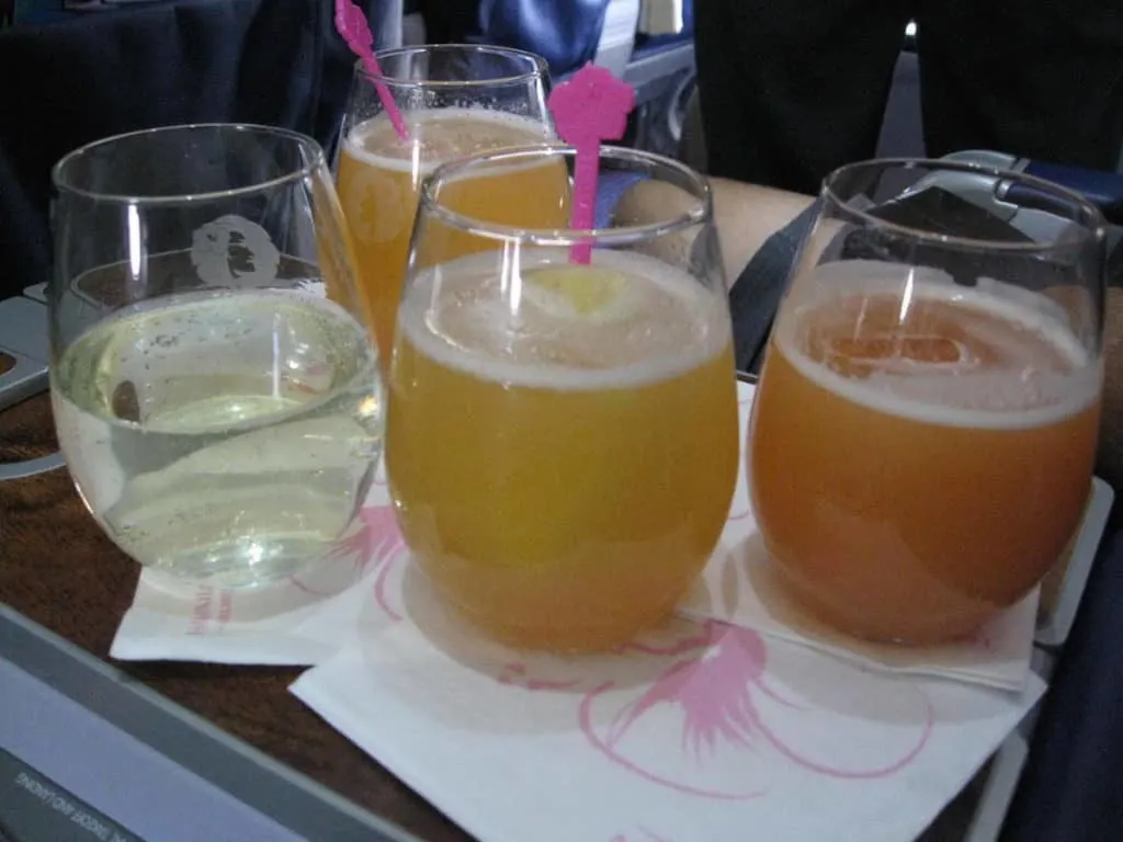 Hawaiian Airlines pre-departures drinks: Na Pua (guava juice and champagne), champagne, and guava juice. Traveling Well For Less